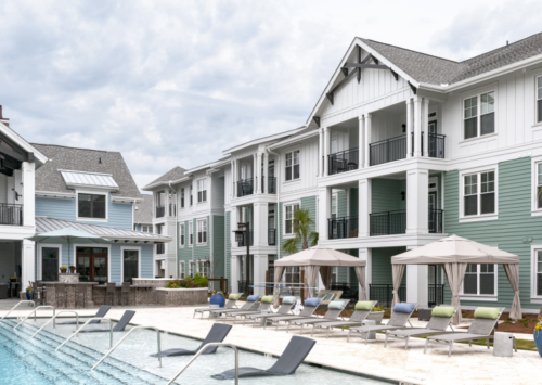 Apartment complex exterior with pool in front